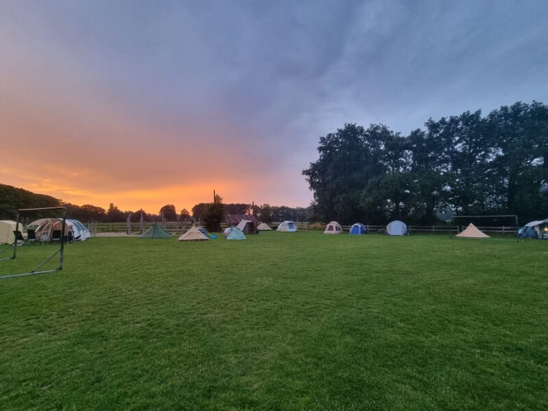 meerdere tenten op het veld met een avond lucht